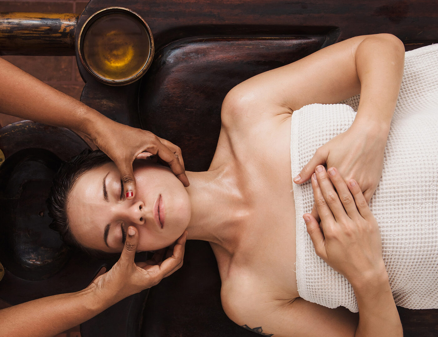 Mujer tumbada recibiendo masaje facial, imagen para cursos online
