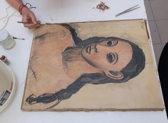 Retrato pintado de mujer con trenzas sobre una tabla; mano con pincel visible