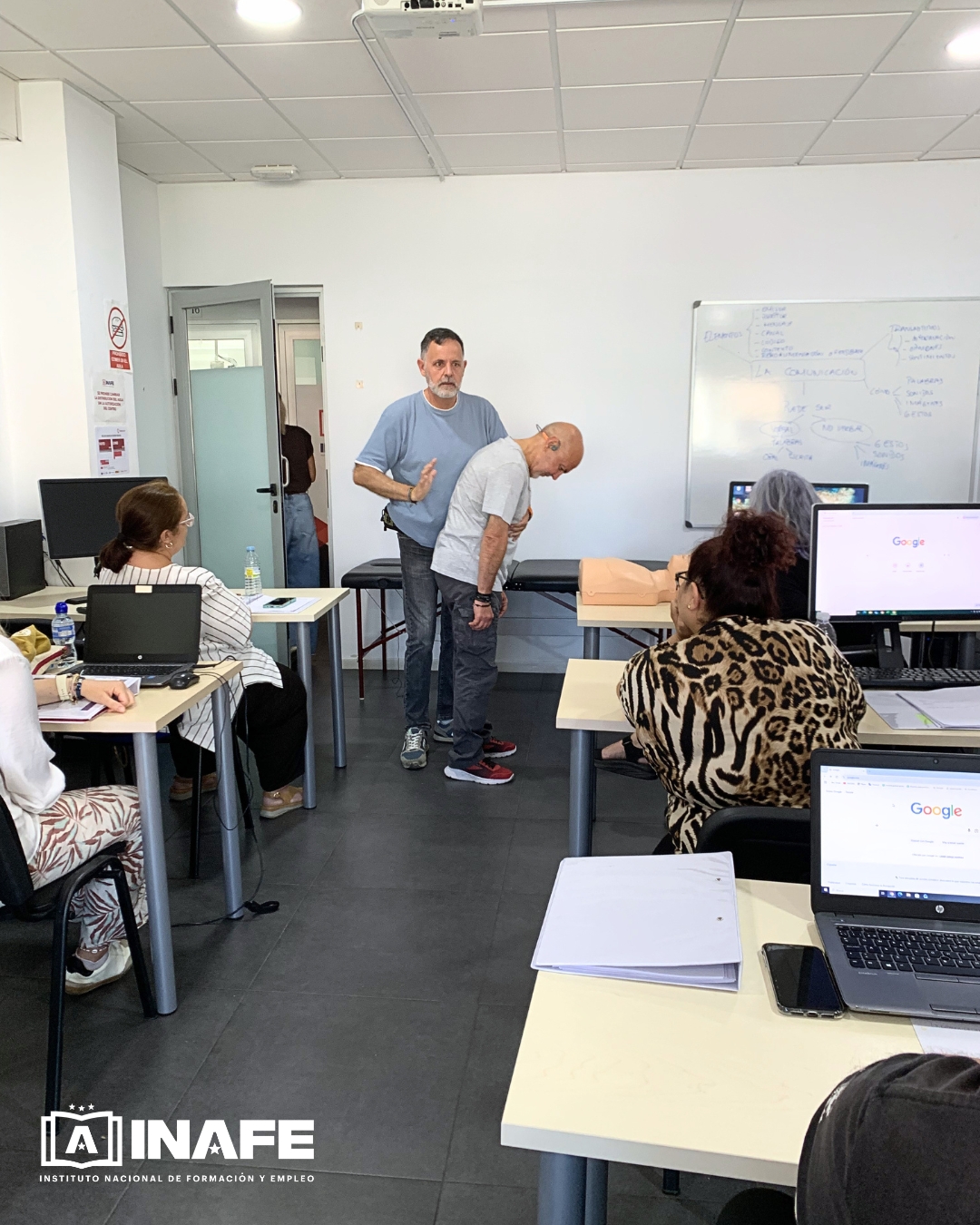 Instructor demostrando la maniobra de Heimlich en aula de formación para el empleo
