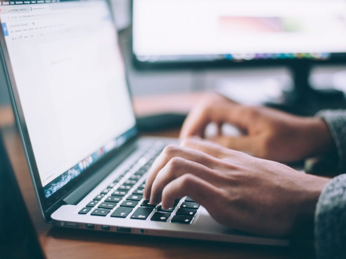 Manos tecleando en un portátil, cursos online