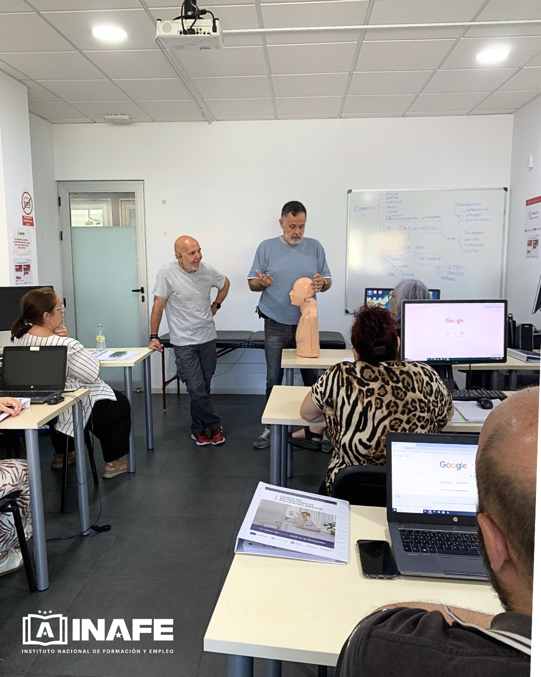 Aula de formación para el empleo con dos instructores mostrando un maniquí de cabeza.