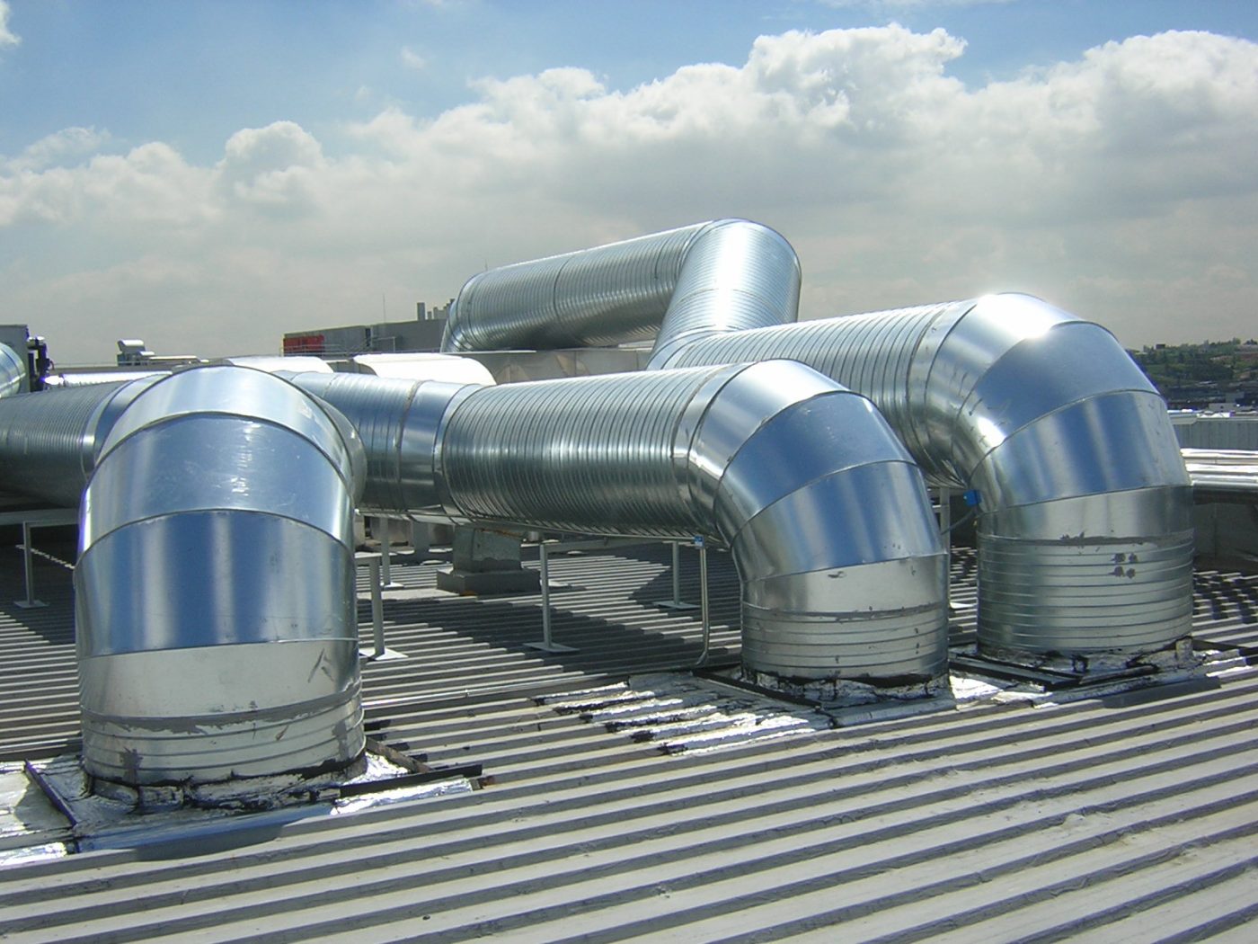 Conductos metálicos de ventilación en tejado industrial, calderería industrial