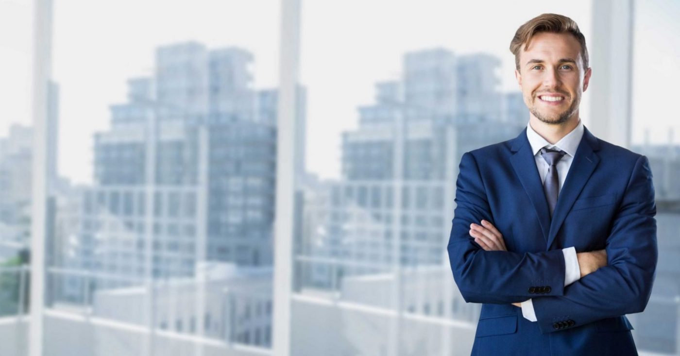 Hombre joven con traje azul y brazos cruzados, formación para el empleo