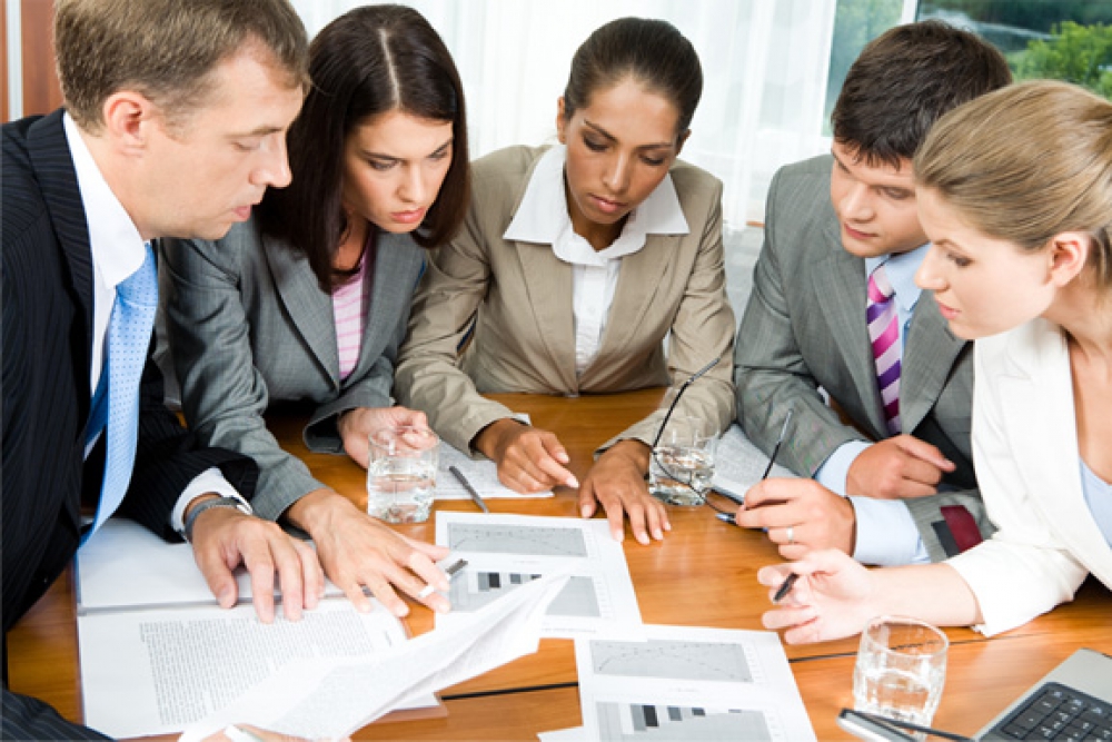 Equipo revisando gráficos y documentos en una reunión, formación para el empleo