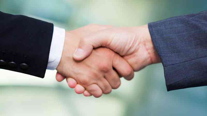 Apretón de manos entre dos personas con traje, formación para el empleo