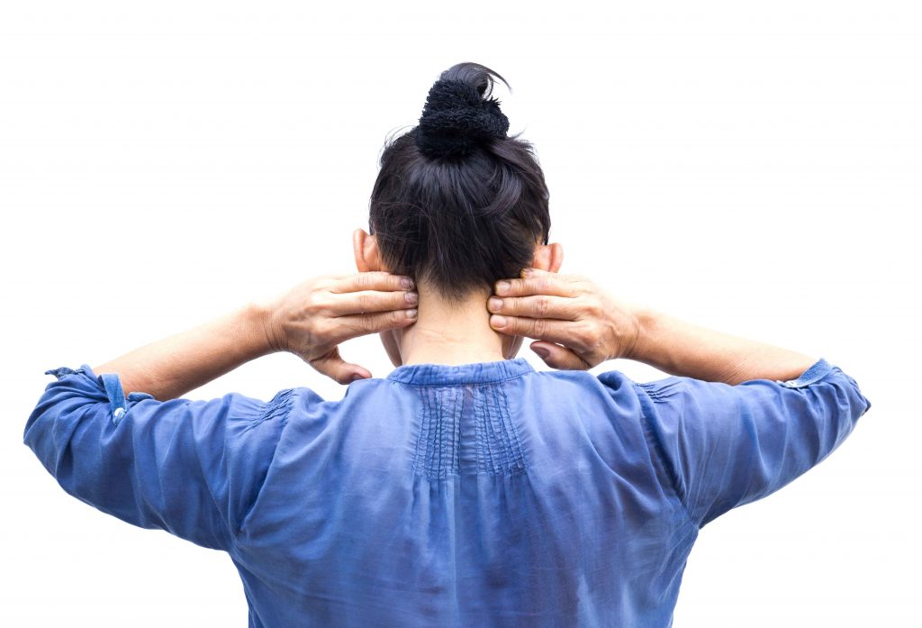 Mujer de espaldas tocándose la nuca con ambas manos, camisa azul, cursos online