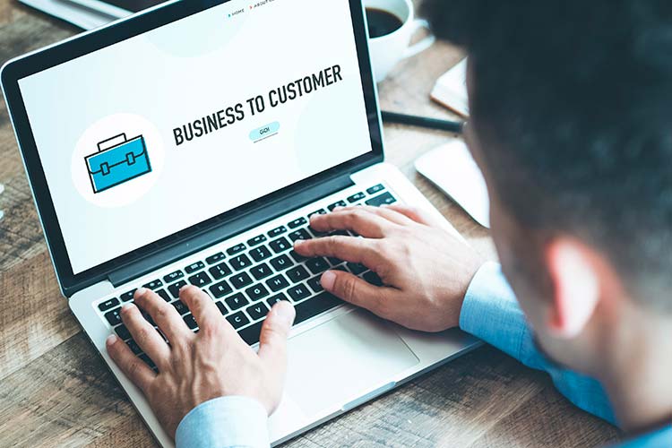 Manos tecleando en un portátil con la pantalla «Business to Customer» — cursos online