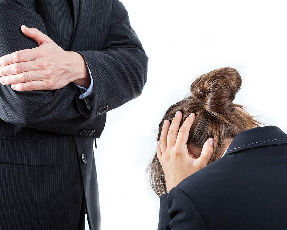 Persona con la cabeza agachada y la mano en la cabeza frente a otra con traje, formación para el empleo