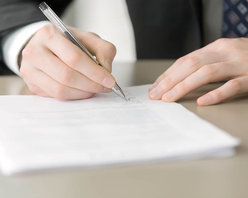 Manos firmando un documento, certificado de profesionalidad