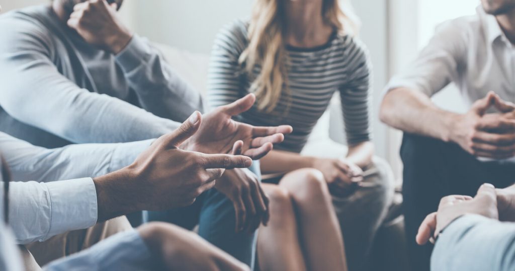 Sesión de formación para el empleo con varias personas sentadas y manos gesticulando