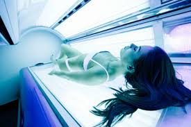 Mujer recostada en cabina de bronceado (solárium), cursos online