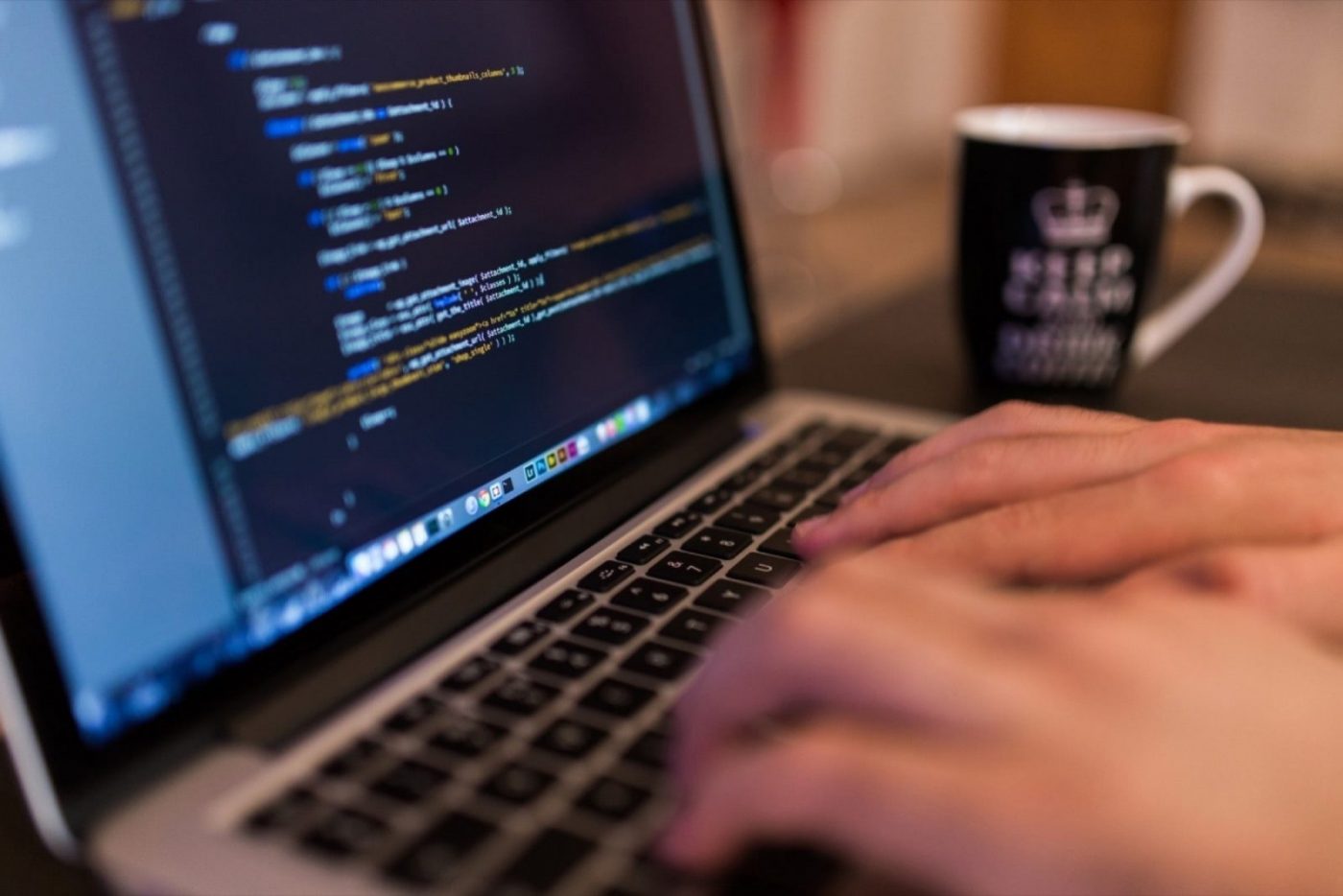 Manos tecleando código en un portátil, cursos online