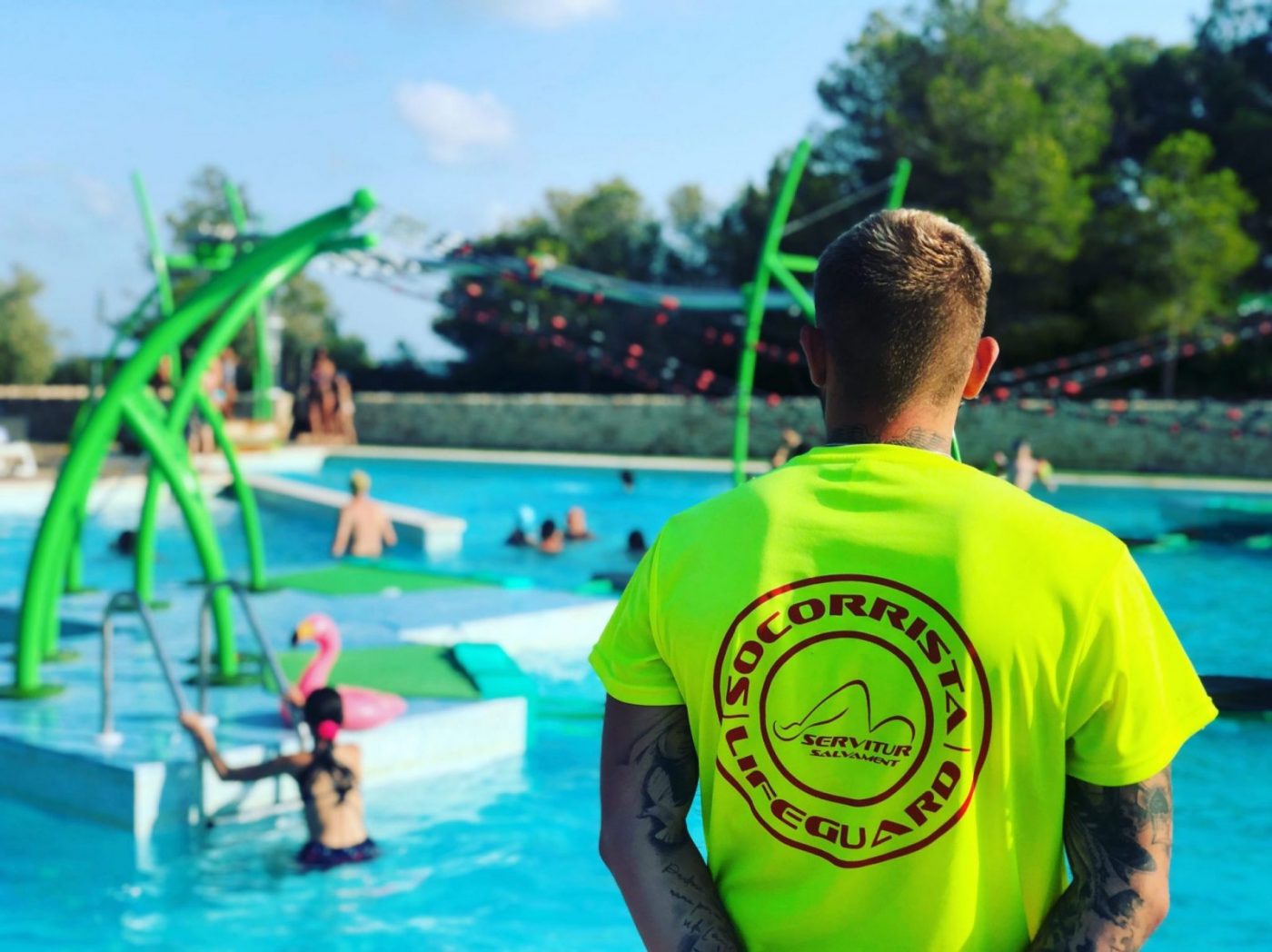 Socorrista de espaldas junto a piscina, formación para el empleo