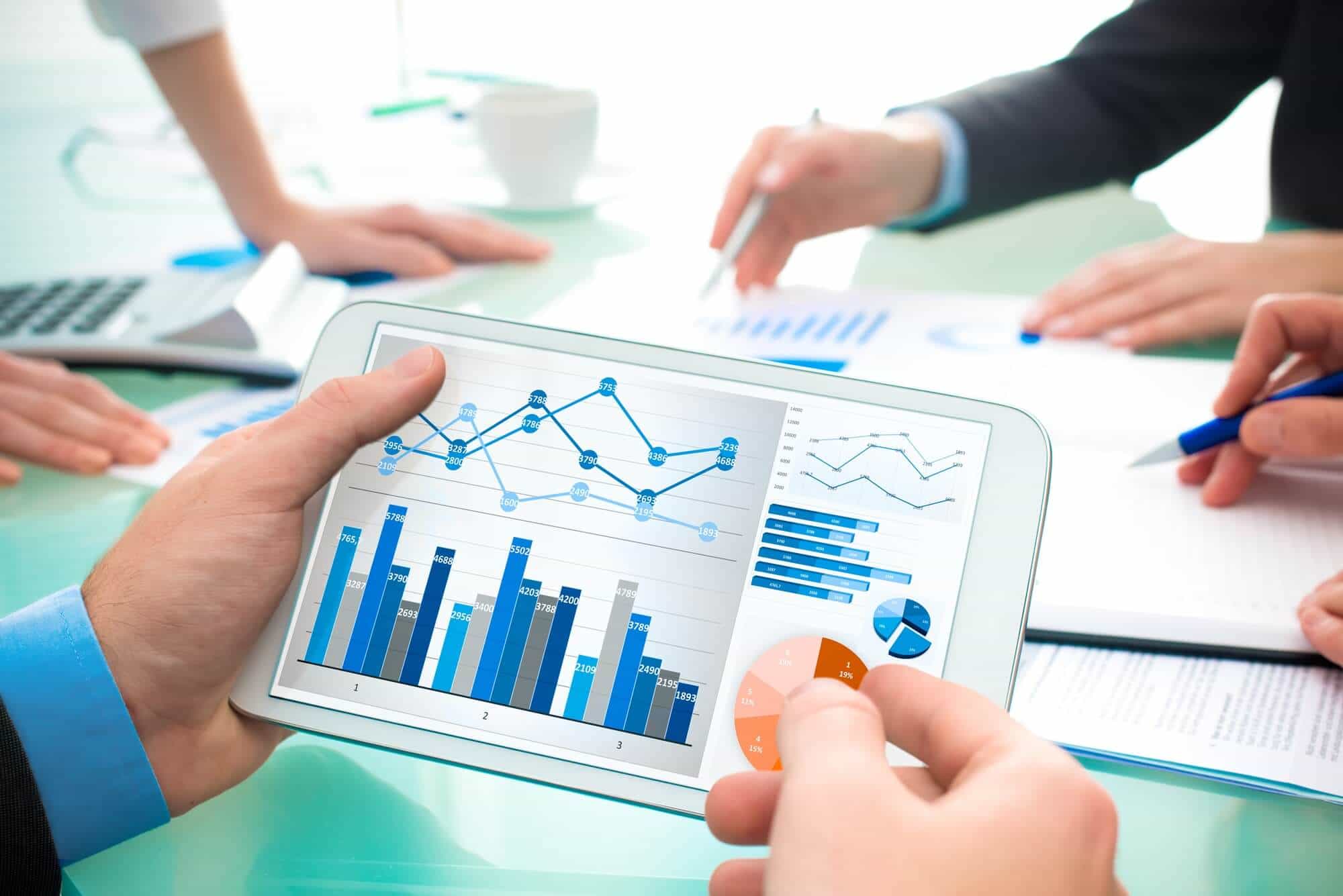 Tablet con gráficos y manos revisando datos, cursos online