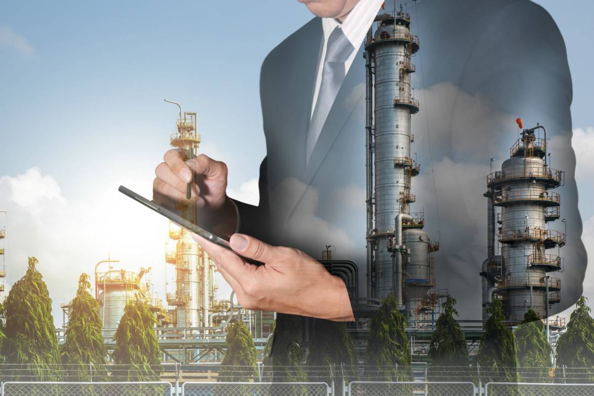 Hombre con traje y tablet sobre planta del sector industrial, cursos sector industrial