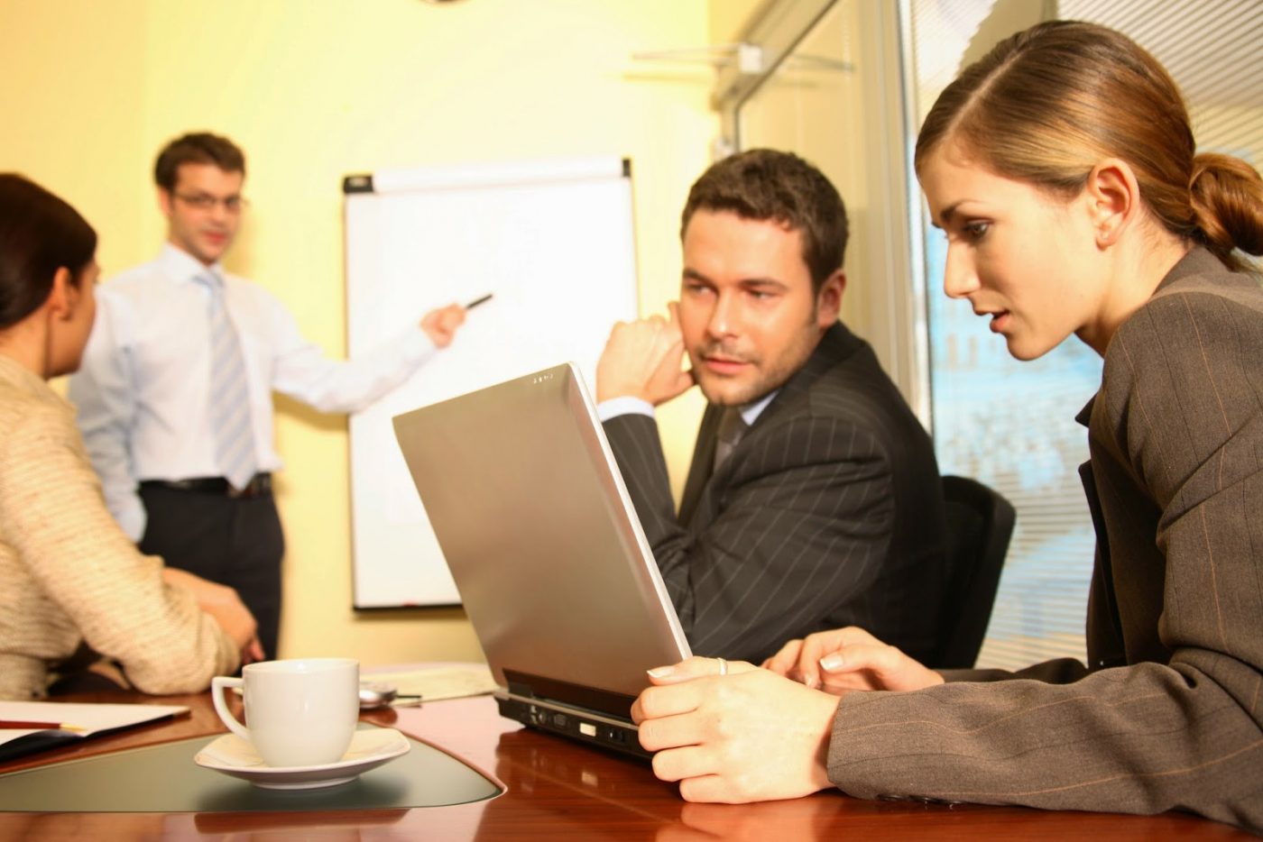 Reunión de trabajo con portátil y pizarra, formación para el empleo