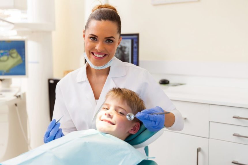 Dentista atendiendo a un niño en sillón dental, cursos con prácticas en empresa