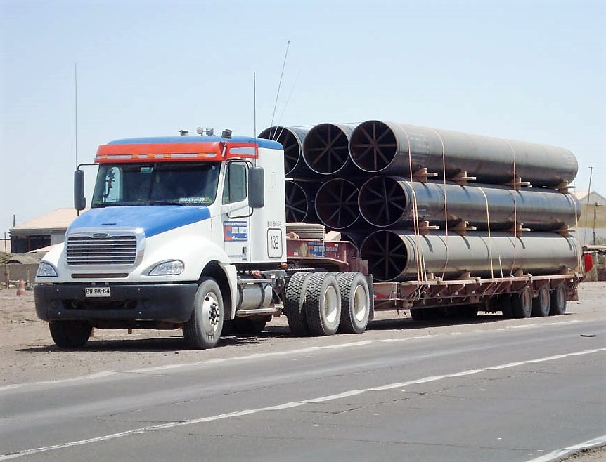 Camión con remolque cargado de tuberías de acero apiladas, material para tubero