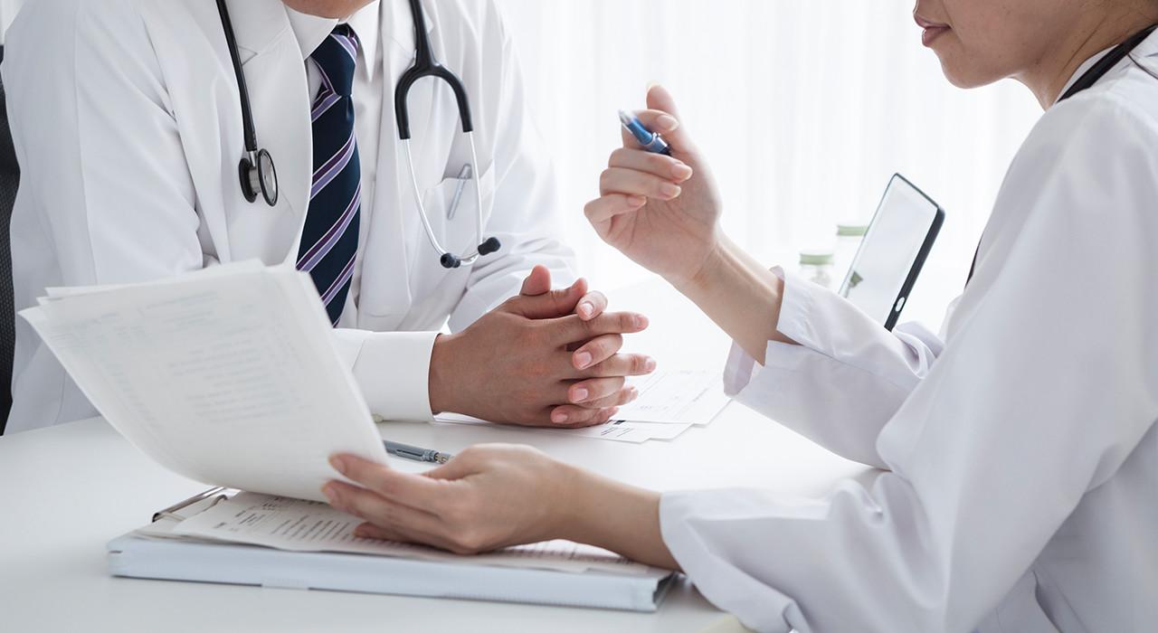 Dos médicos en bata blanca revisando documentos, formación para el empleo