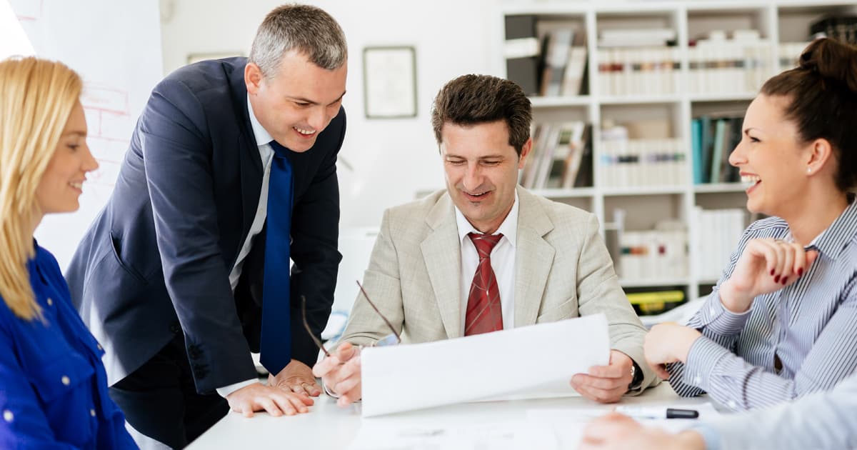 Cuatro profesionales en reunión revisando documentos, formación para el empleo