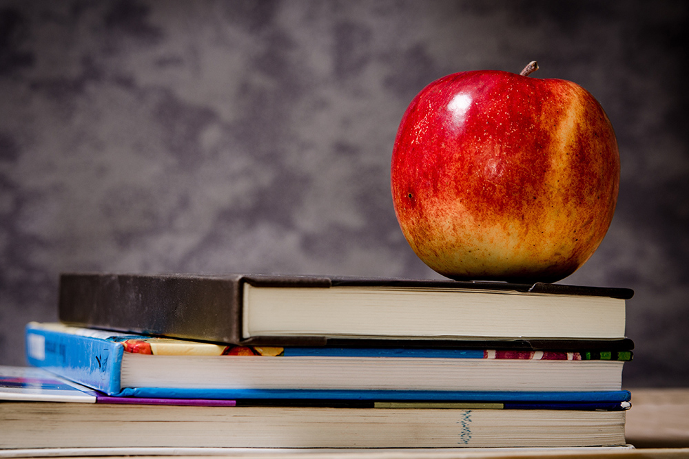 Manzana roja sobre pila de libros, formación para el empleo