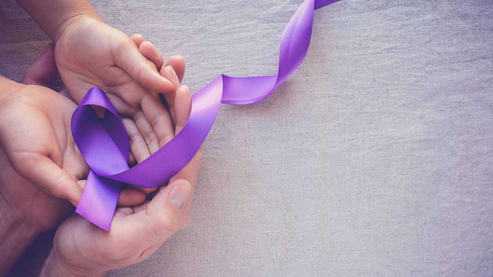 Manos sosteniendo un lazo morado, formación para asociaciones