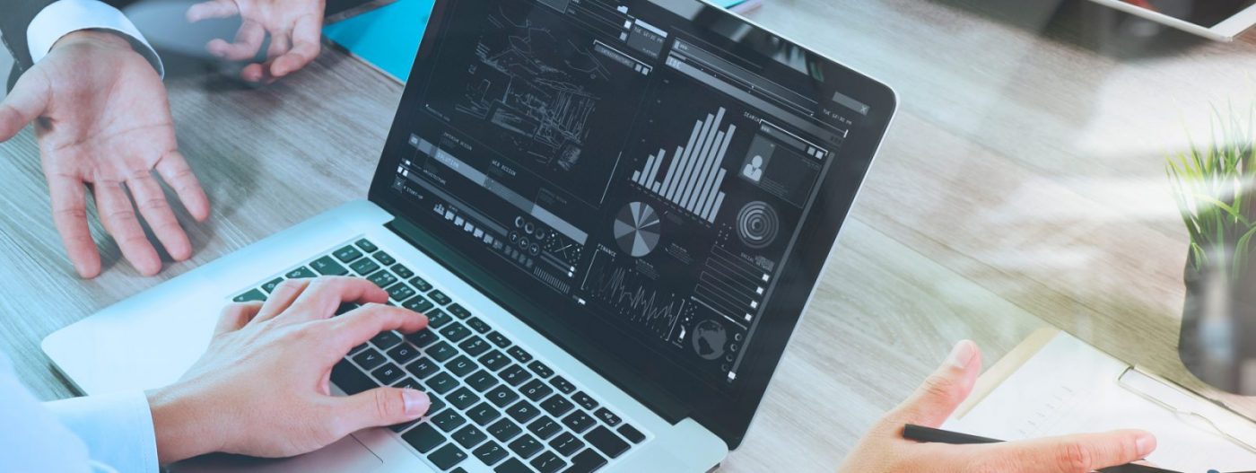 Portátil con gráficas en pantalla y manos trabajando, cursos online