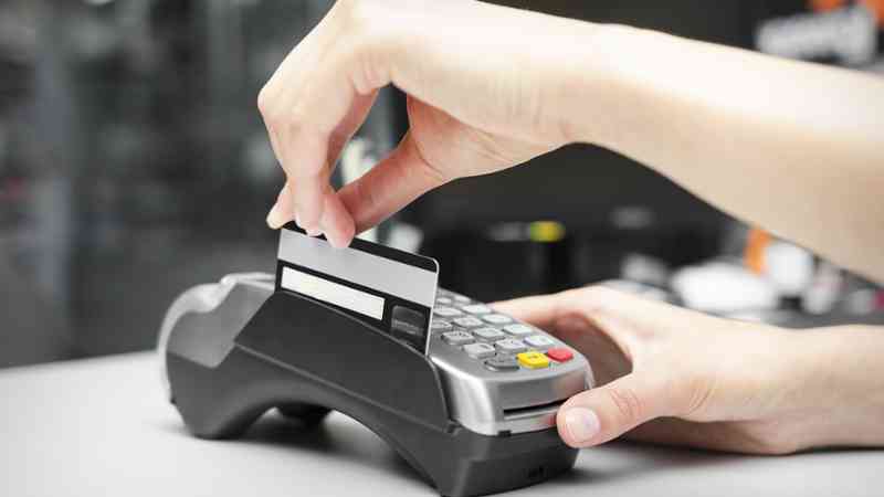 Terminal de pago con tarjeta insertada y manos realizando pago electrónico, cursos online