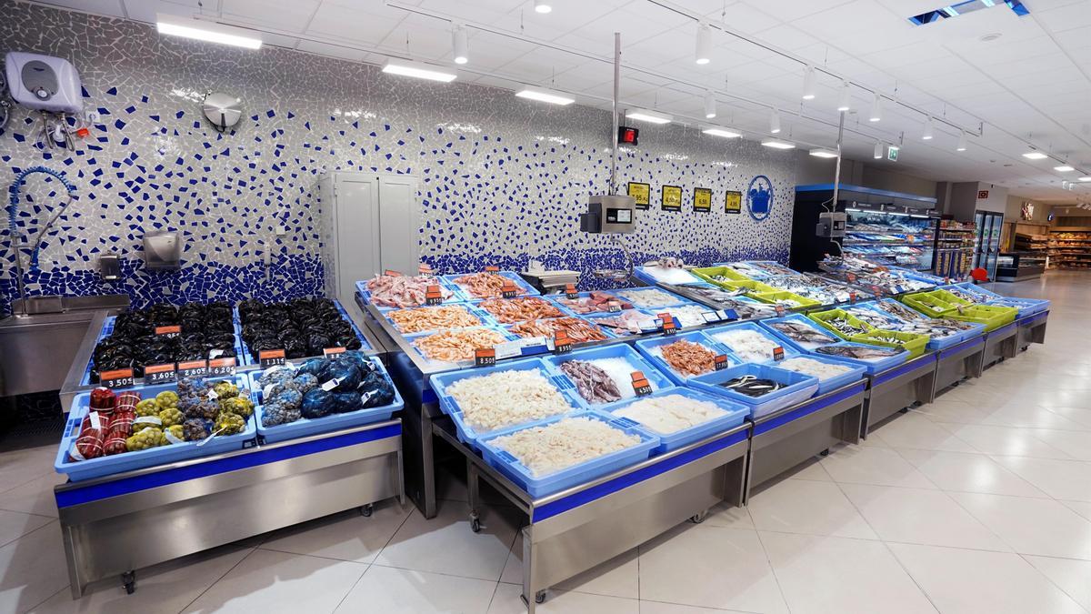 Mostrador de mariscos en supermercado con bandejas azules y varios pescados y mariscos, cursos sector industrial