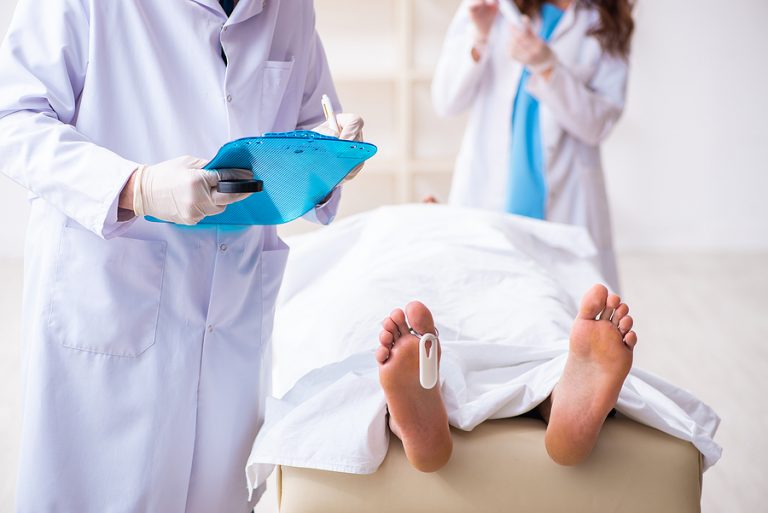 médico forense junto a cadáver con etiqueta en el dedo - formación para administraciones públicas