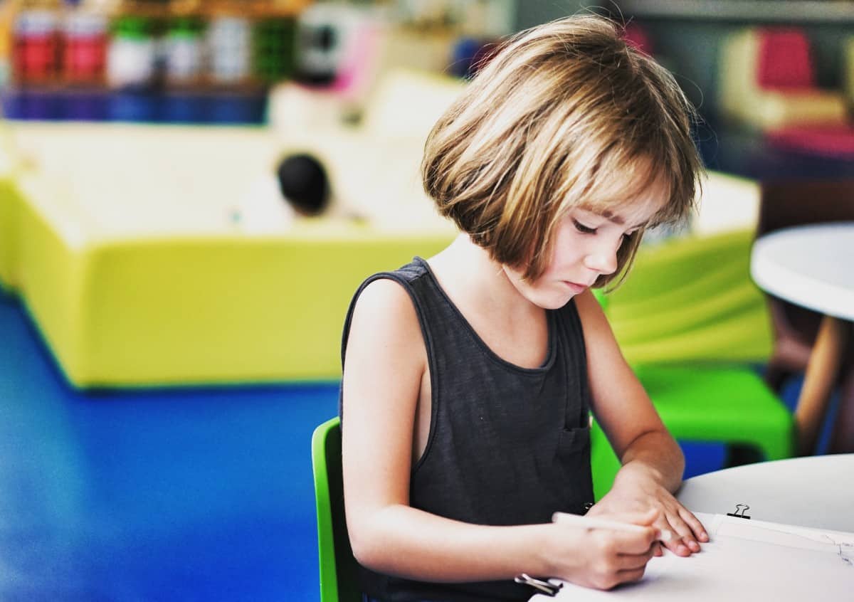 Niña dibujando en un aula, cursos gratuitos