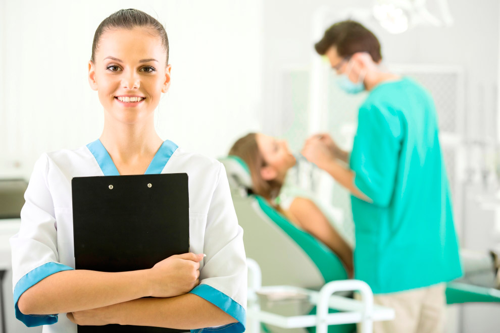 Auxiliar dental con carpeta en clínica dental, formación para el empleo