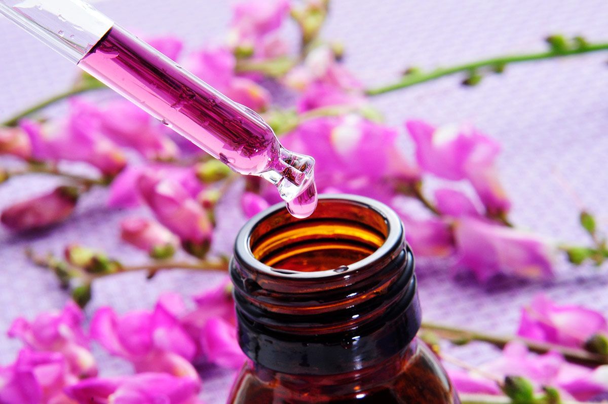 Pipeta con gota de líquido rosa sobre frasco ámbar — formación para el empleo