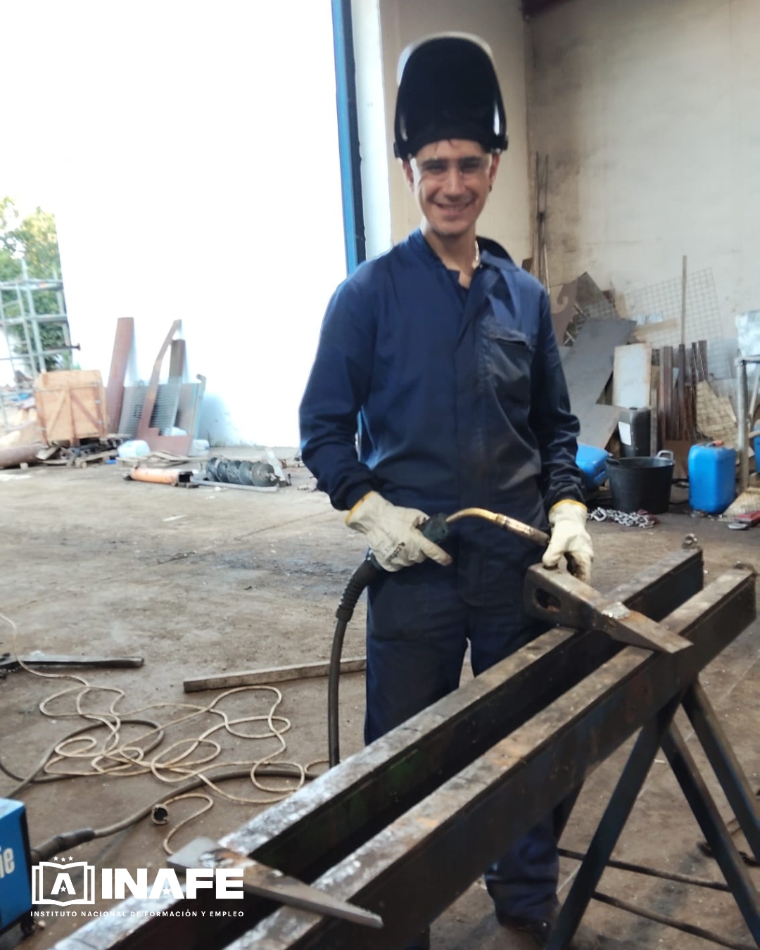 Operario con equipo de soldadura en taller industrial