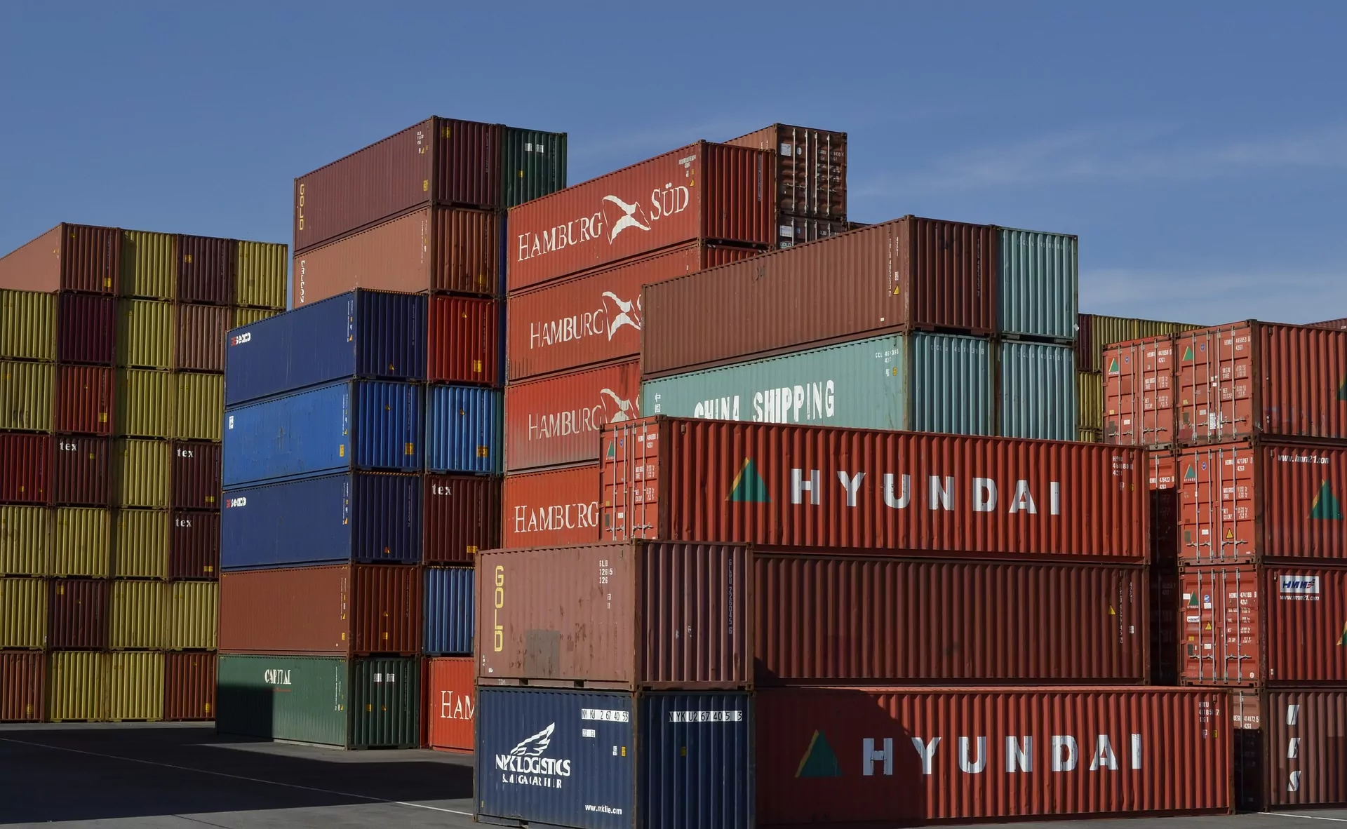 Contenedores de carga apilados en puerto, cursos sector industrial