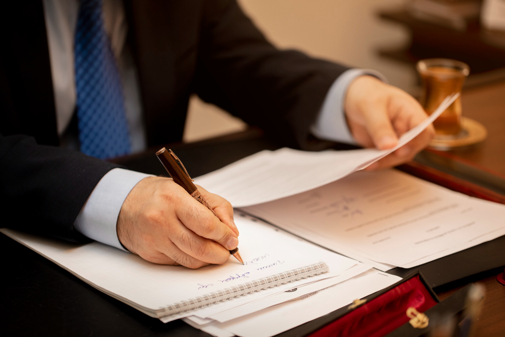 Persona con traje firmando un documento (certificado de profesionalidad)