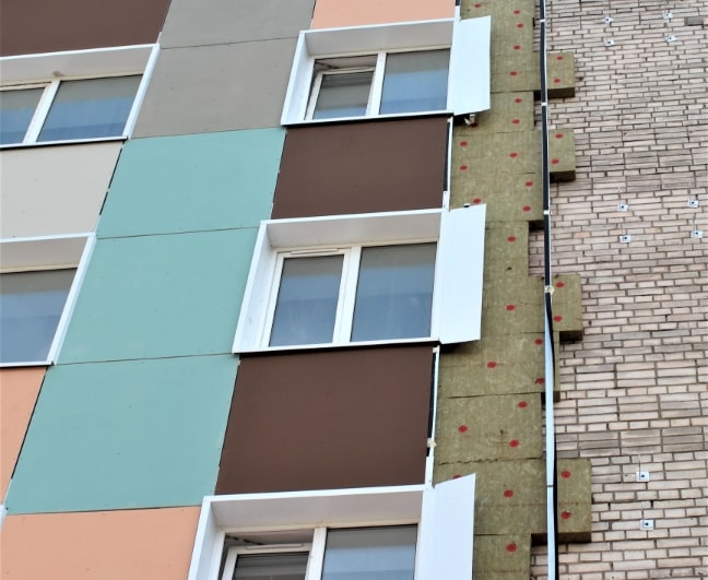 Fachada en obra con paneles de aislamiento y lana mineral y ventana; cursos sector industrial