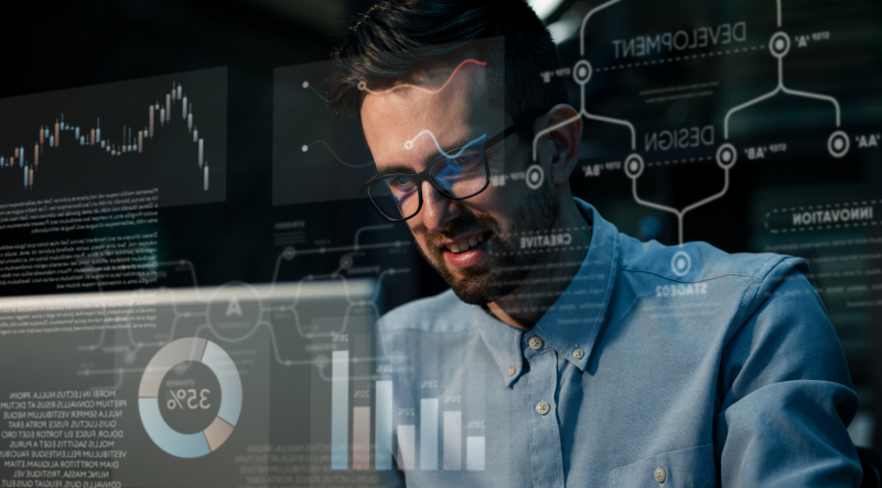 Hombre con gafas frente a pantalla con gráficos, diagramas y paneles de datos — cursos online