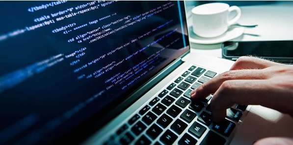 Manos tecleando código en un portátil — cursos online
