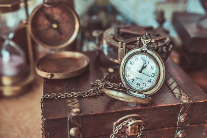 Reloj de bolsillo antiguo sobre un cofre con cadena, cursos gratuitos
