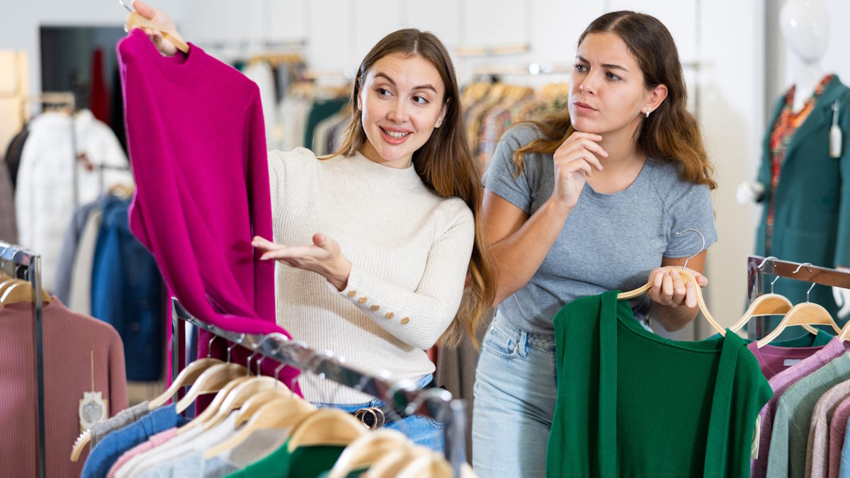 Dos mujeres comparando jerséis en una tienda — formación para el empleo