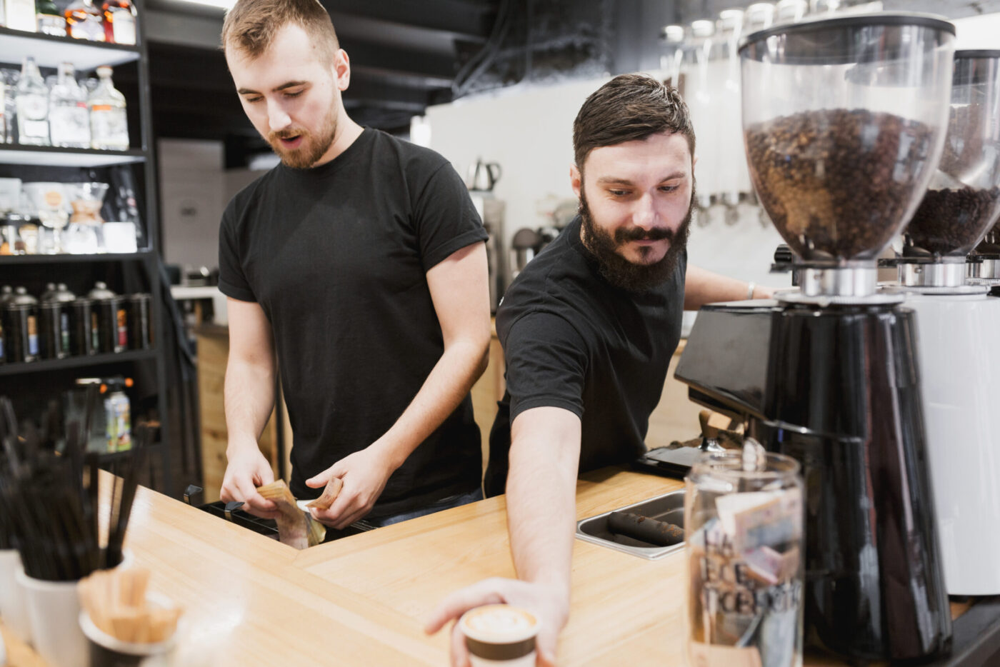 Dos baristas sirviendo café en la barra — cursos con prácticas en empresa