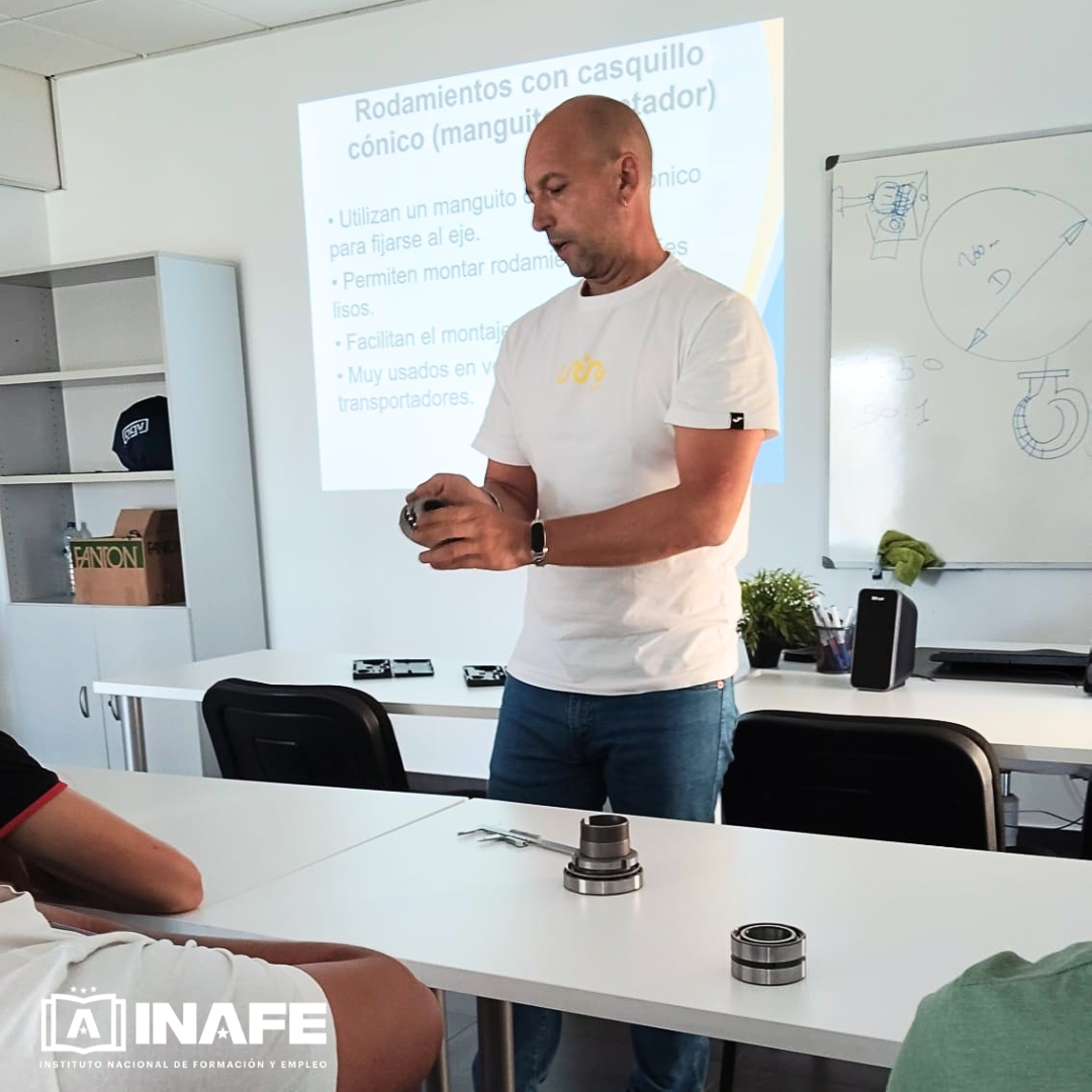 Instructor mostrando rodamientos en clase de mantenimiento industrial