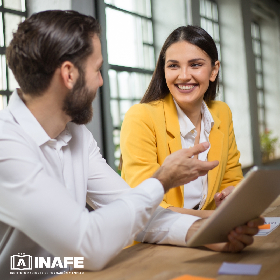 Mujer sonriendo y hombre conversando con tablet, formaci&oacute;n para el empleo