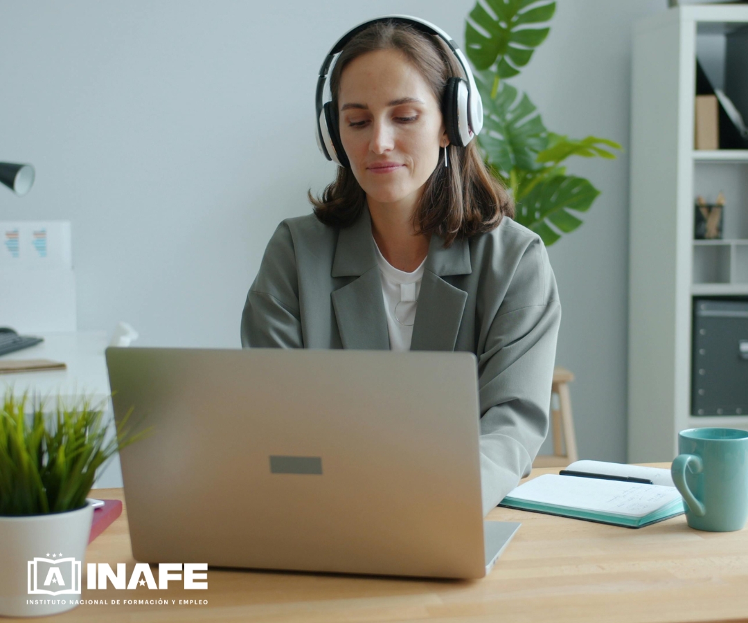 Mujer con auriculares ante un portátil (cursos online)