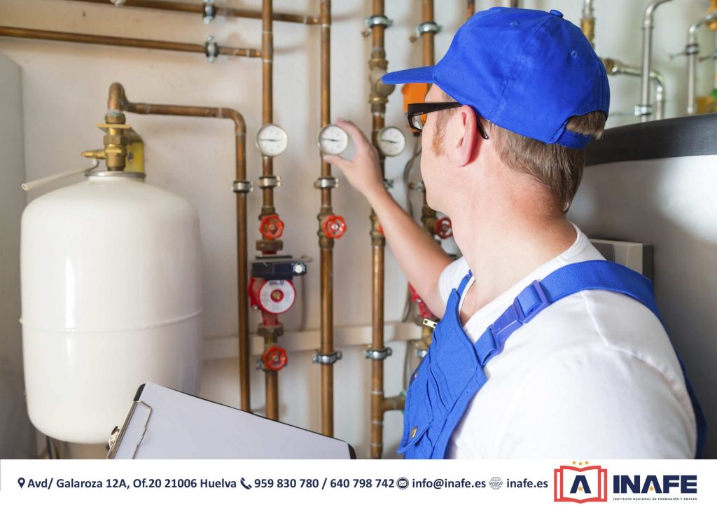 Técnico tubero ajustando un manómetro en tuberías con válvulas