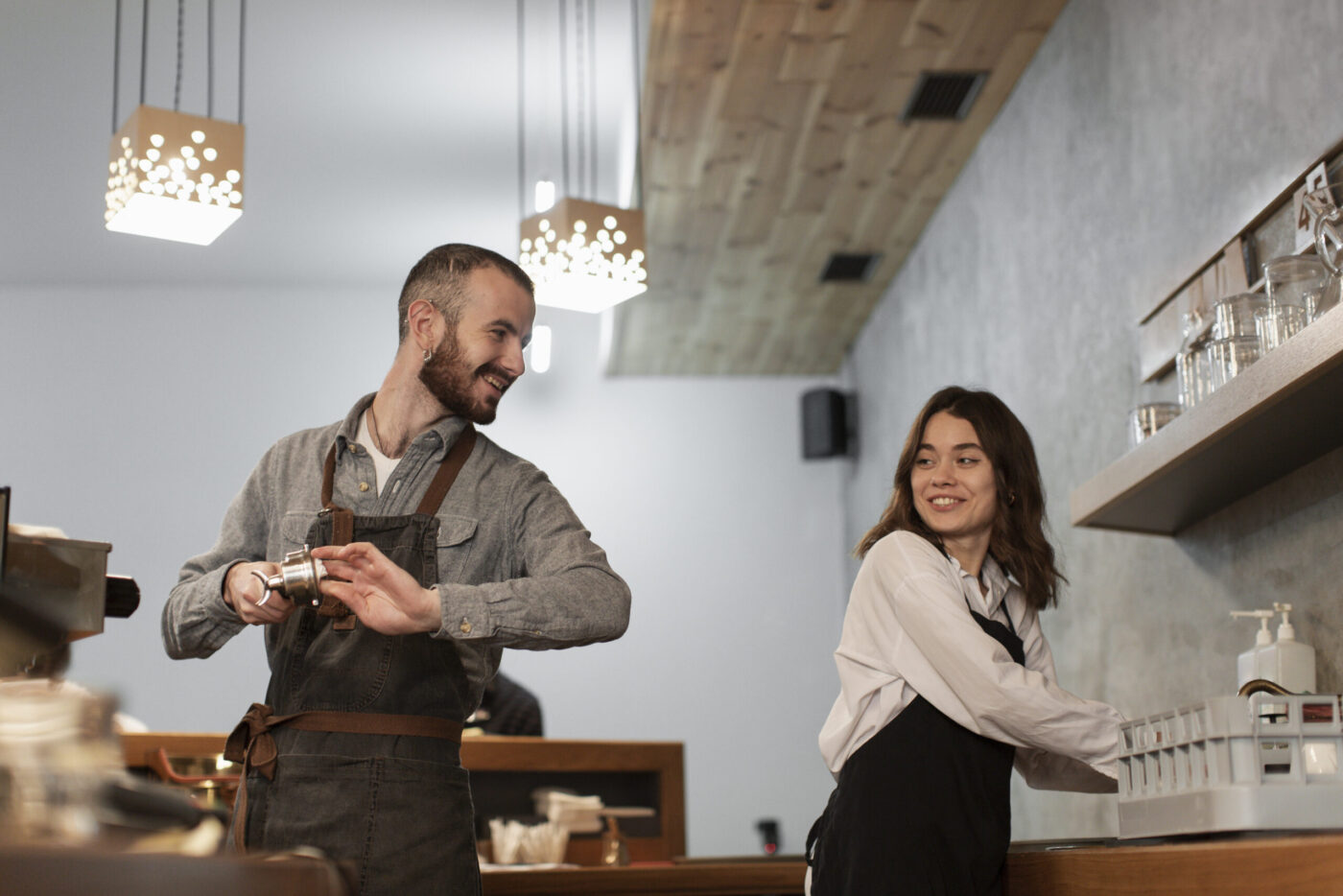 Baristas sonrientes trabajando en barra, formación para el empleo