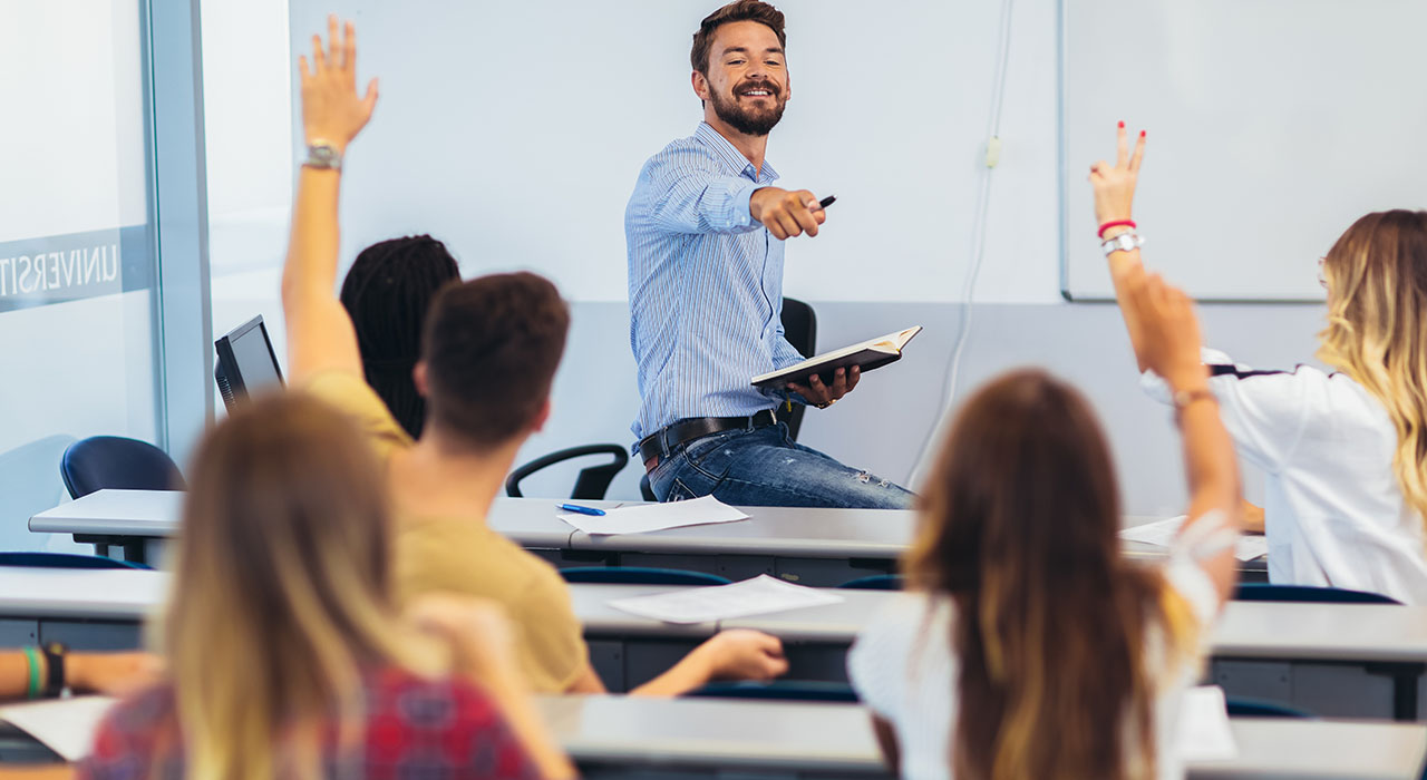 Profesor señalando a estudiantes con manos alzadas en aula, formación para el empleo