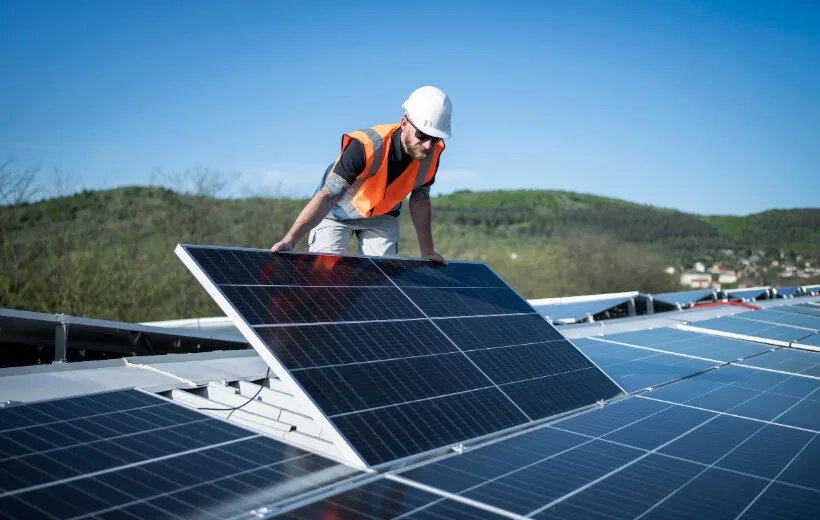 Operario con casco y chaleco instalando un panel solar, cursos sector industrial