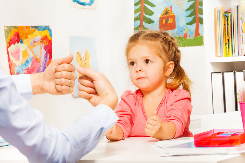 Niña en sesión con terapeuta realizando ejercicios manuales, formación a medida